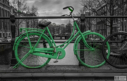 Зеленый велосипед на фоне черно-белого Амстердама