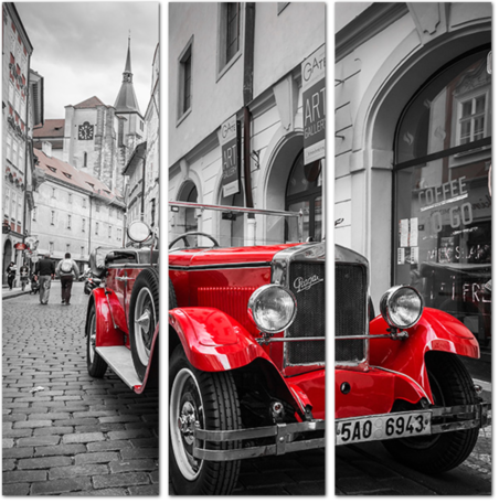 Красный ретро автомобиль на фоне черно-белой Праги