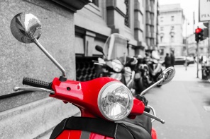 Красный скутер на фоне черно-белого фото Милана