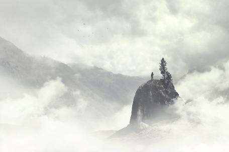 Человек на вершине горы в тумане