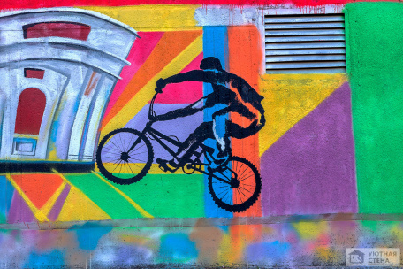 Велосипедист на геометрическом разноцветном фоне