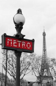 Входной знак Парижского метро на фоне Эйфелевой башни