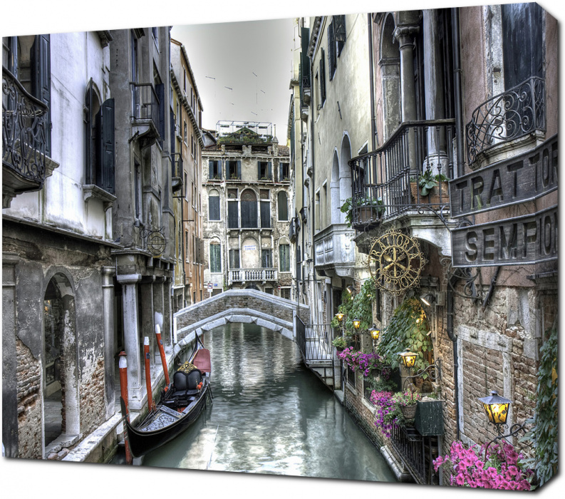 Небольшой мост и гондола на канале Венеции. Италия