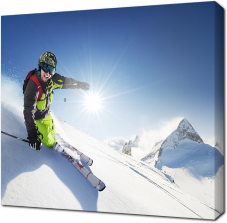 Лыжник смотрит в объектив, съезжая с горы