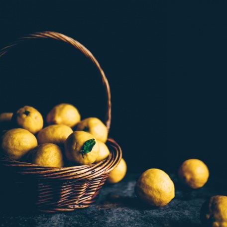 Корзина лимонов на темном фоне