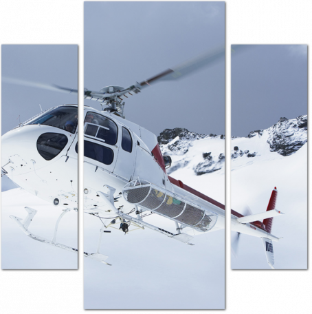 Вертолет летит над снежными горными вершинами