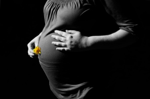 Черно-белое фото беременной с желтым цветком