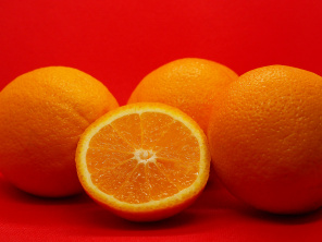 Яркие апельсины на красном фоне