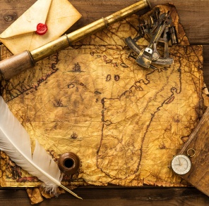 Секстант, подзорная труба и конверт на старинной карте