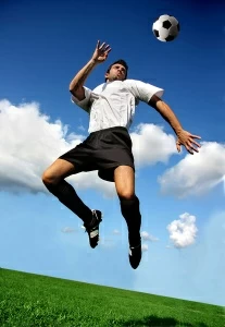 Футболист отбивает мяч головой