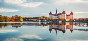 Утренний замок Морицбург в отражении озера