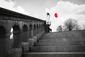 Одинокая девушка с красными воздушными шарами