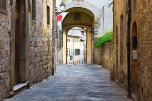 Узкий переулок со старыми зданиями в Италии