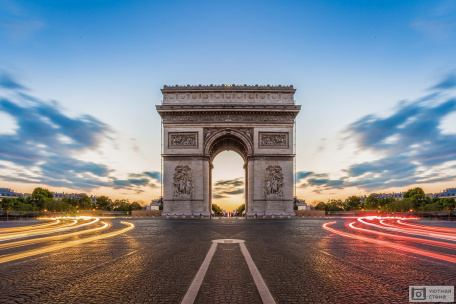 Триумфальная арка на Елисейских полях ночного Парижа. Франция