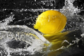Брызги воды на желтом лимоне