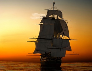 Корабль с парусами в море на закате