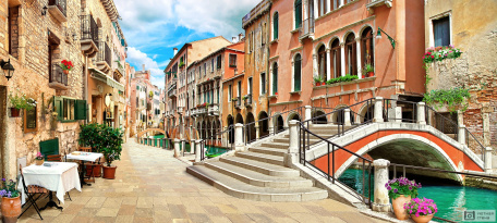 Узкая улочка вдоль канала Венеции