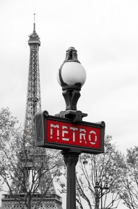 Красный знак метро на фоне Эйфелевой башни