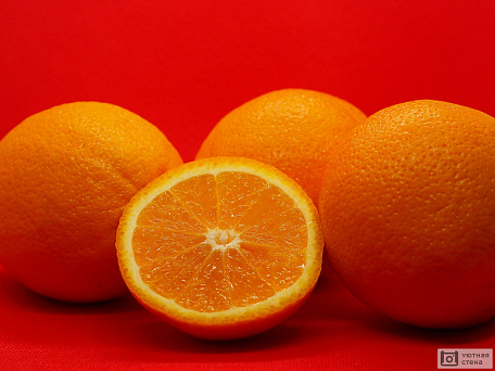 Яркие апельсины на красном фоне