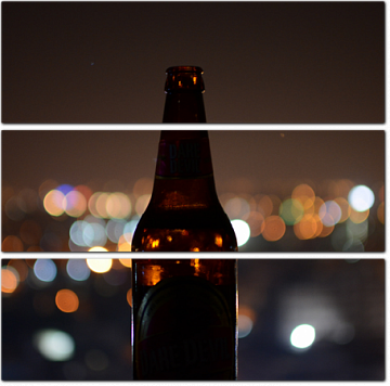 Пивная бутылка на фоне ночного города