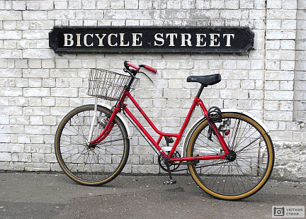 Красный велосипед на фоне черно-белой кирпичной стены
