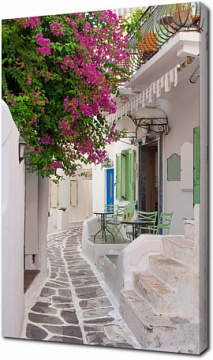 Узкая улочка греческого острова с бугенвиллеями. Миконос.