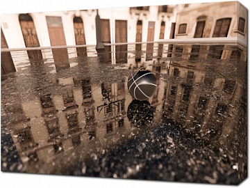 Баскетбольный мяч на влажном асфальте