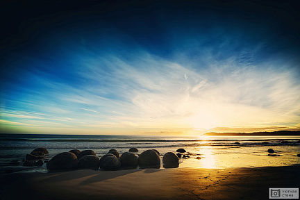 Круглые камни на берегу на закате