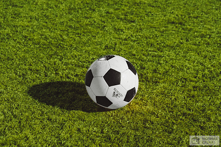 Футбольный мяч на зеленом газоне
