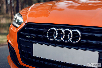 Эмблема на передней решетке оранжевого Audi