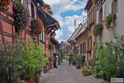 Старые узкие улицы с множеством цветов на окнах
