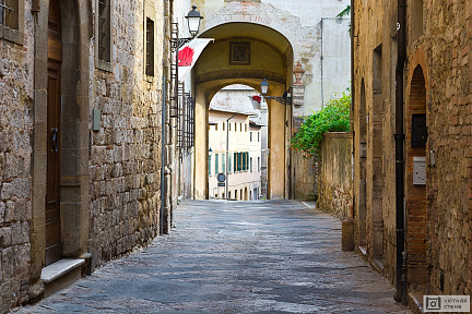 Узкий переулок со старыми зданиями в Италии