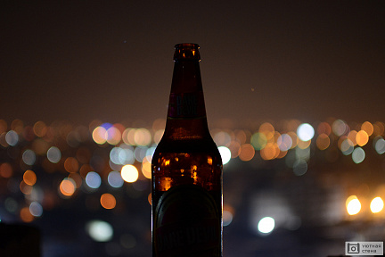 Пивная бутылка на фоне ночного города