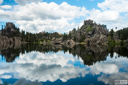 Отражение каменистого берега в озере