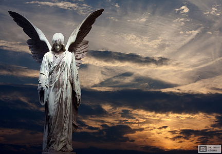 Скульптура ангела на фоне заката