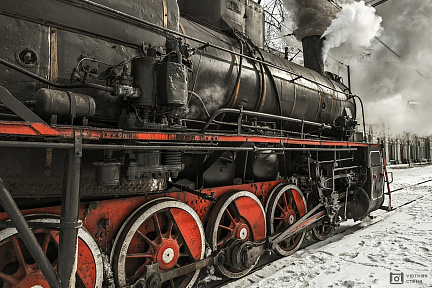 Старый советский паровоз стоит на перроне вокзала