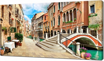 Узкая улочка вдоль канала Венеции